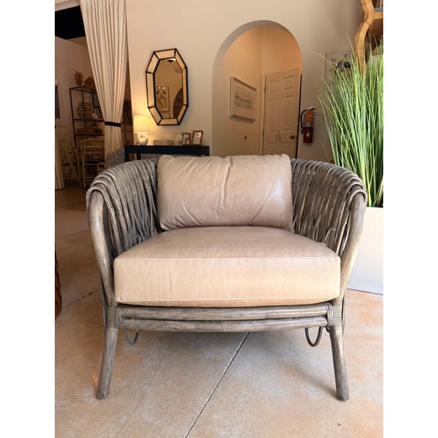 Contemporary organic lounge chair featuring a sculptural rattan frame in a weathered greige finish that creates an airy,...