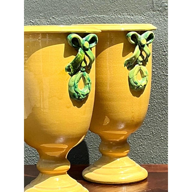 Exemplifying the cheerful elegance of mid-century Italian ceramics, this pair of pedestal vases features a radiant golden-...