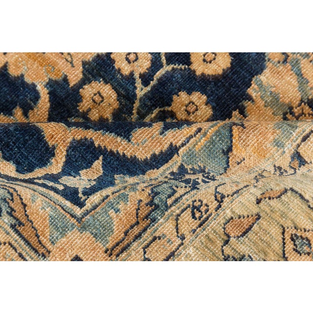 A late 19th century Persian Tabriz rug, the midnight blue field with a lattice of palmettes and leafy vinery containing...