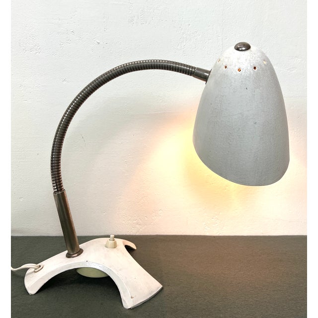This table lamp from the 50’s has a real charm by its simplicity. A chromed adjustable stem connects the craw feet base...