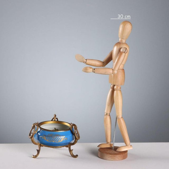 Porcelain bowl painted in polychrome and gold. Interior decorated with a floral composition. Tripod base and bronze ring....