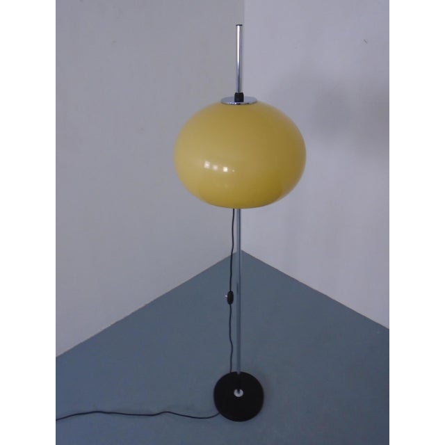 Floor lamp from the 1970s. The lampshade is height-adjustable and made of plastic. When switched off, the lampshade is...