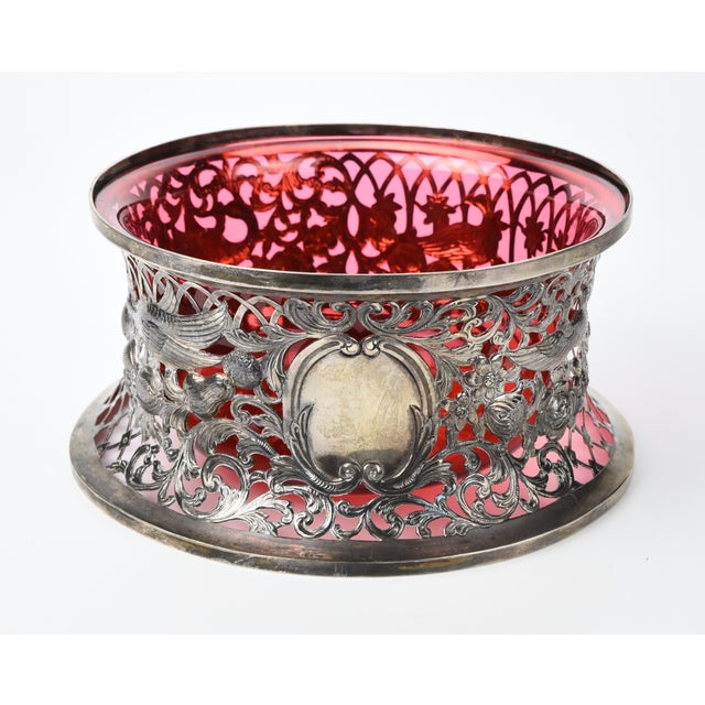 An elegant Irish silver dish ring decorated with detailed relief birds on swags of fruit and flowers against an openwork...