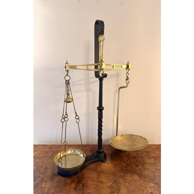 Quality pair of antique Victorian balance scales, having a central cast iron support holding brass weighting pans...