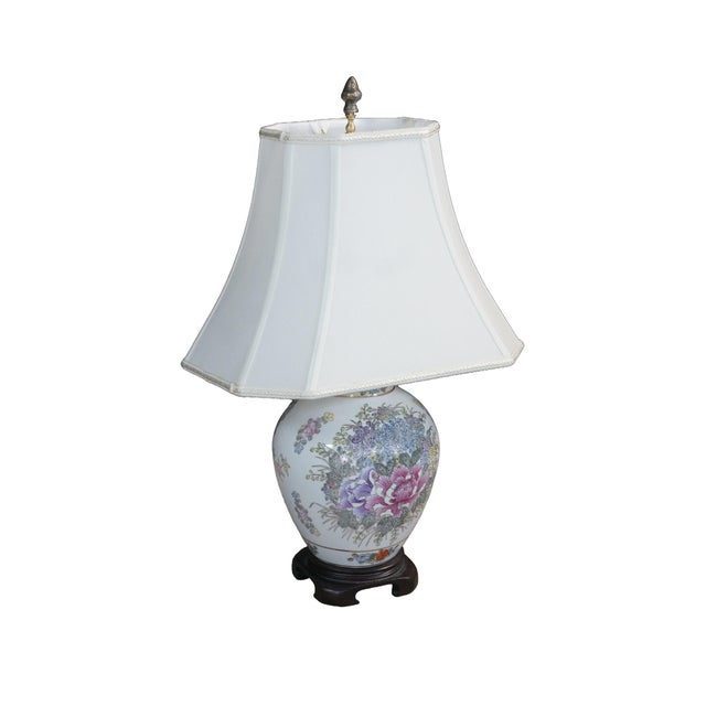 This vintage Chinoiserie ginger jar table lamp features a rounded white porcelain body hand-painted with vibrant pink,...