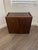This is a mid-century modern vanitystorage ottoman featuring a dark rosewood base and a beige boucle fabric cushion. This...