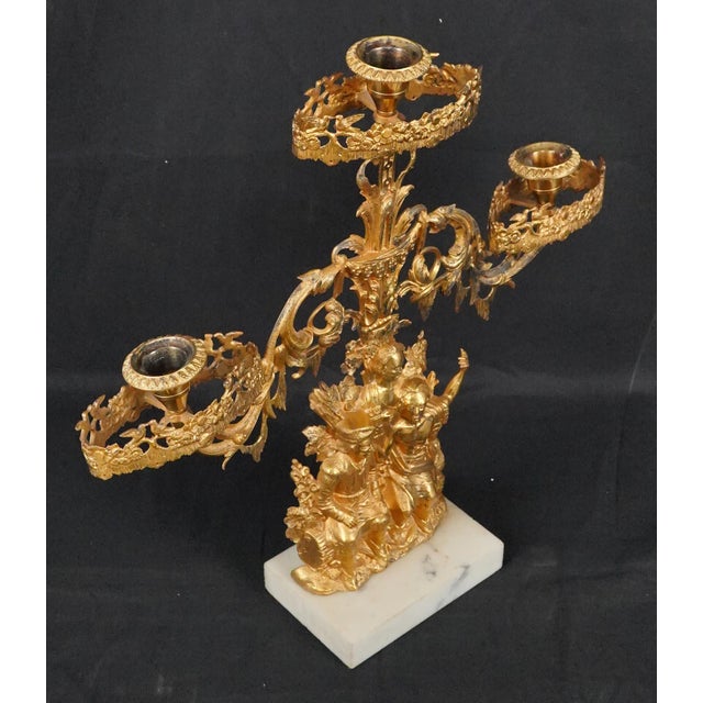 Victorian style girandole candelabra made of gilded brass mounted on a marble plinth. This particular design is known as...