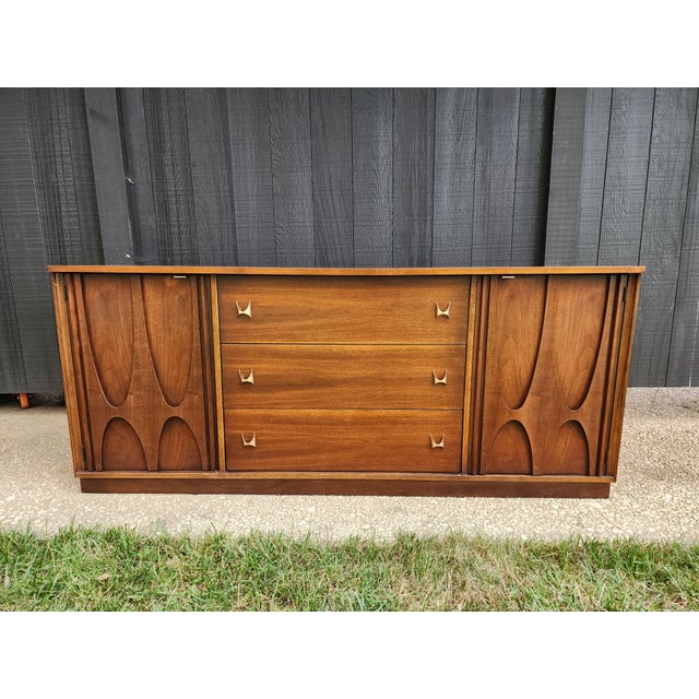 An enduring icon of American mid-century modern design, this authentic Broyhill Brasilia triple dresser showcases the...