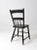 An antique primitive farmhouse chair with a beautifully aged black painted finish. The simple wooden form features a plank...
