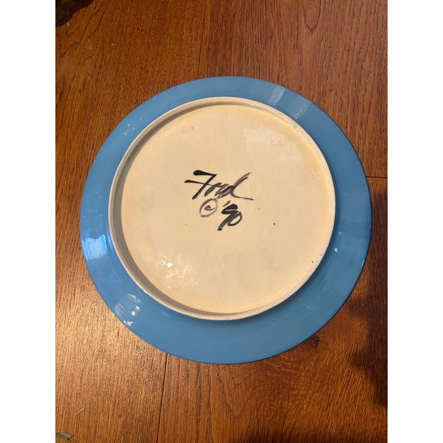 This is a hand-painted 11-inch ceramic plate by artist Denise Ford from 1990 featuring a striking Arabian desert motif...