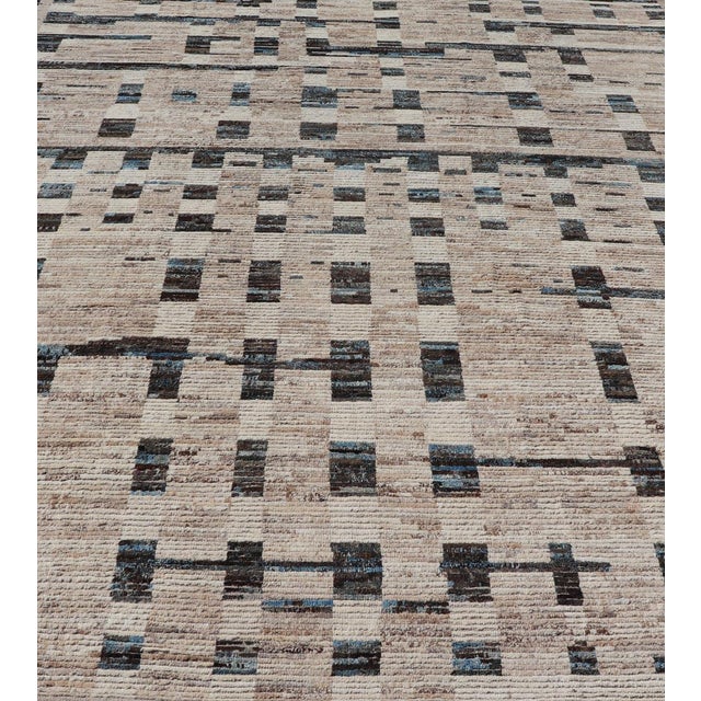 Measures: 9'4 x 12'3. This modern casual tribal rug has been hand-knotted in wool. The rug features a modern Sub-geometric...