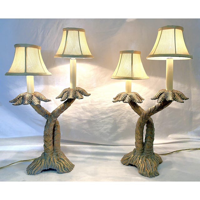 Great pair of vintage Palm Beach Chic table lamps from the late 20th century. Each has a double crossed palm tree design...