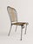 A striking set of four mid-century French patio or garden dining chairs crafted from elegant black-painted wrought iron...