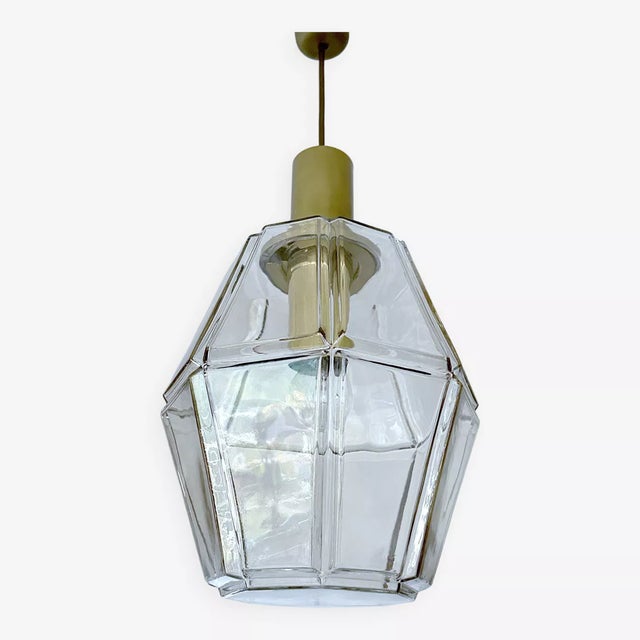 Large pendant light by limburg, featuring an oversized polyhedral glass shade with highlighted edge, polished brass...