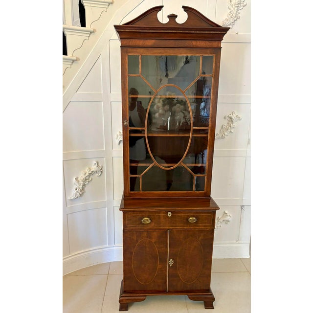 Outstanding quality antique Victorian mahogany inlaid bookcase having a mahogany swan neck pediment, shaped cornice above...