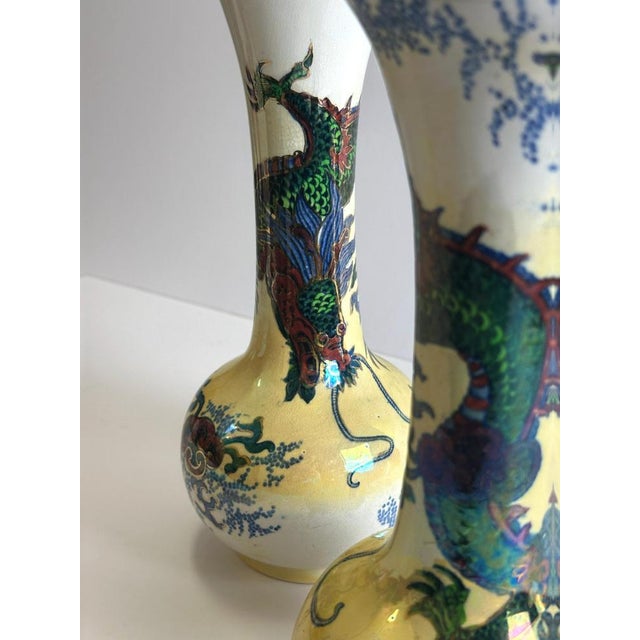 Two tall, flared-neck vases from the Dragon pattern series designed by Frederick Rhead for Wood & Sons’ Bursley Ware line,...