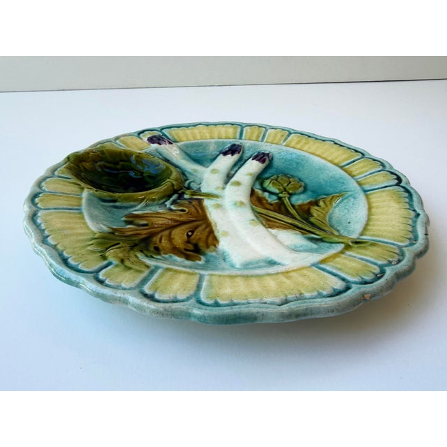 A beautiful and highly collectible antique French majolica asparagus plate, crafted during the celebrated golden age of...