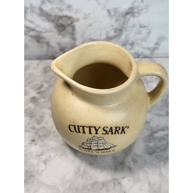 This charming Black on Creamware pitcher features a transfer ware image of the classic ship, 'Cutty Sark'. Made for Cutty...
