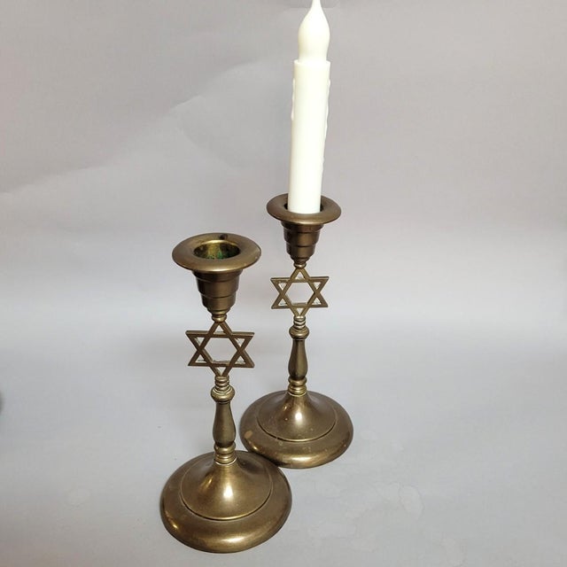 A handsome pair of vintage brass Judaica candlesticks featuring openwork Star of David motifs incorporated into the stems....