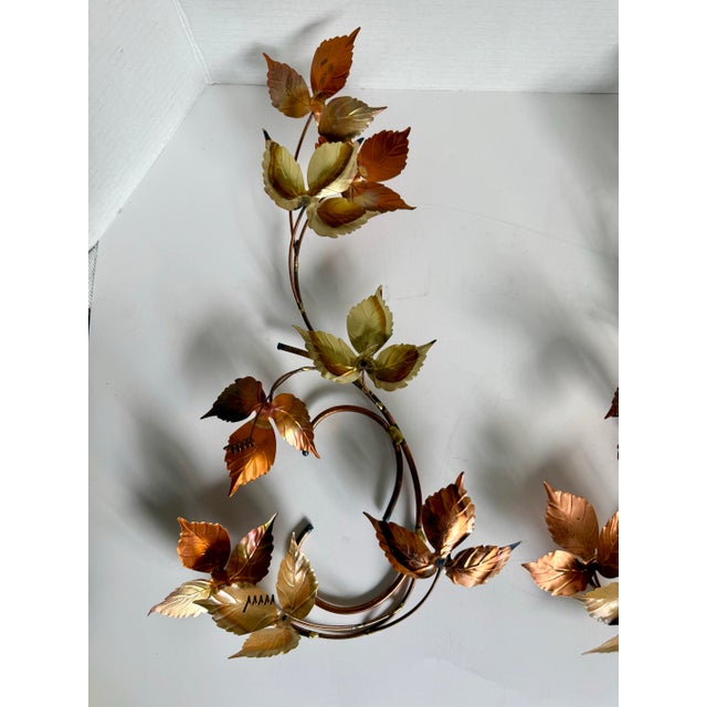 Dating to the mid-20th century, this elegant pair of Curtis Jere-style tole wall sculptures features gracefully scrolling...