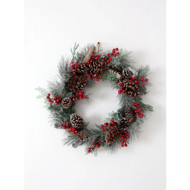 Bring the holiday spirit to your home with this vintage Christmas wreath. Featuring natural pinecones, faux greenery, and...