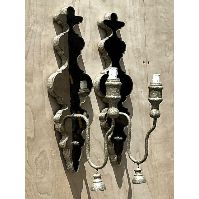 Exuding Hollywood Regency glamour and vintage sophistication, this pair of wall sconces features scalloped mirrored...