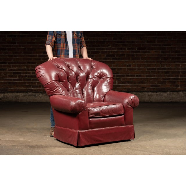 Generously proportioned lounge chair with a coordinating ottoman, upholstered in rich burgundy leather. The chair features...