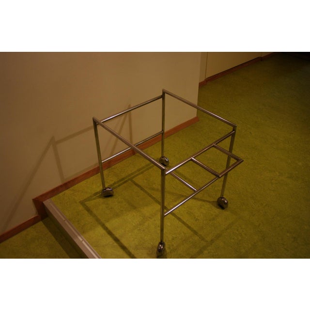 This elegant service trolley embodies the iconic design of the 1960s. The white laminate and rosewood trays rest on a...
