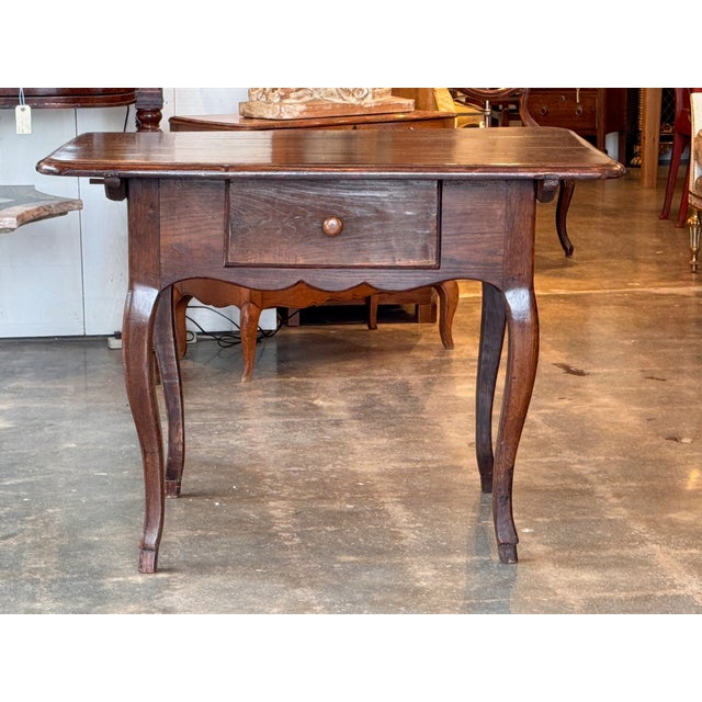 A French oak side table with a rectangular top and softly rounded corners, the surface showing a gently worn finish and...