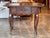 A French oak side table with a rectangular top and softly rounded corners, the surface showing a gently worn finish and...