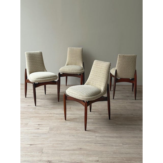 Set of four dining chairs imported from Italy, dating to approximately the late 1950s–1960s. The sculpted wood frames...