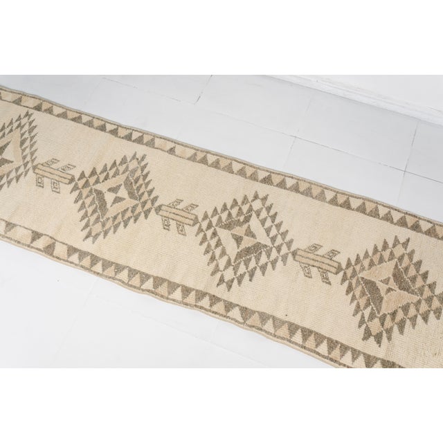 This is a vintage Turkish Oushak rug from the Mid 20th Century. The piece was hand-knotted.