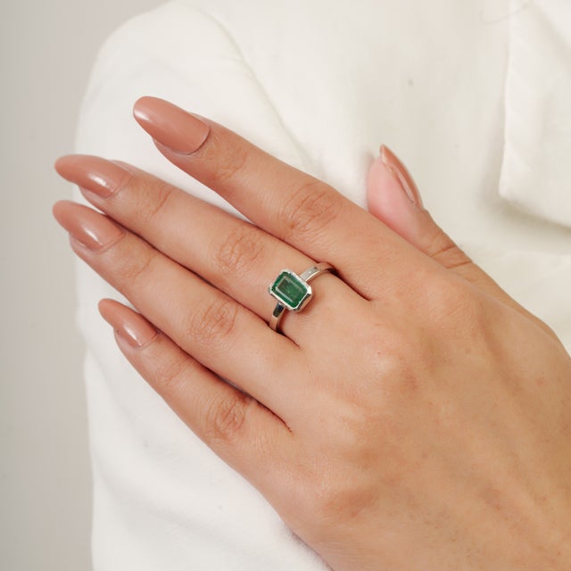 Elegant in its simplicity, this 0.57 CTW Emerald Cut Emerald Ring is crafted in solid 925 sterling silver, offering a...
