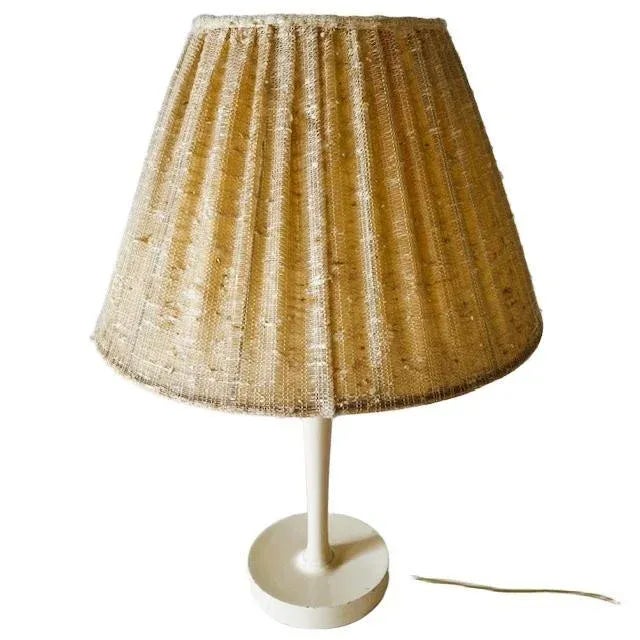 Vintage Danish design table lamp with a wooden base and linen shade from the 1960s. This retro table lamp has a round base...