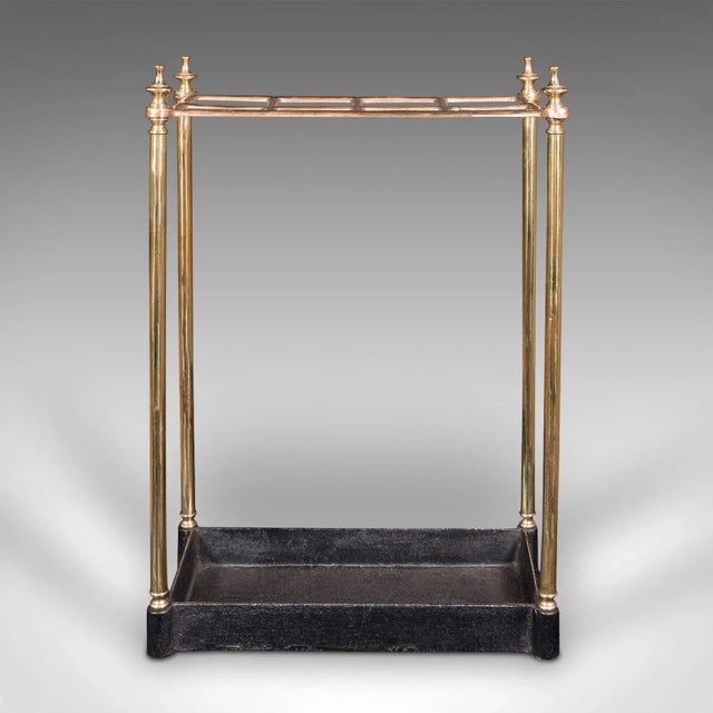 This is an antique segmented stick stand. An English, brass and cast iron hallway rack, dating to the late Victorian...