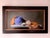 This artwork features a serene still life composition, showcasing a vibrant blue jug, a pair of sand dollars, and a warm...