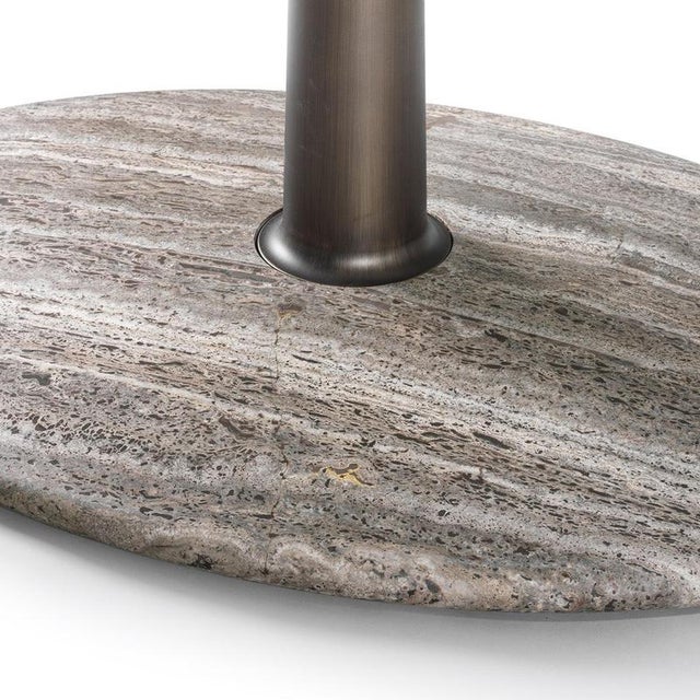A sculptural round table defined by a single central column and a refined balance of volumes, it brings a strong...