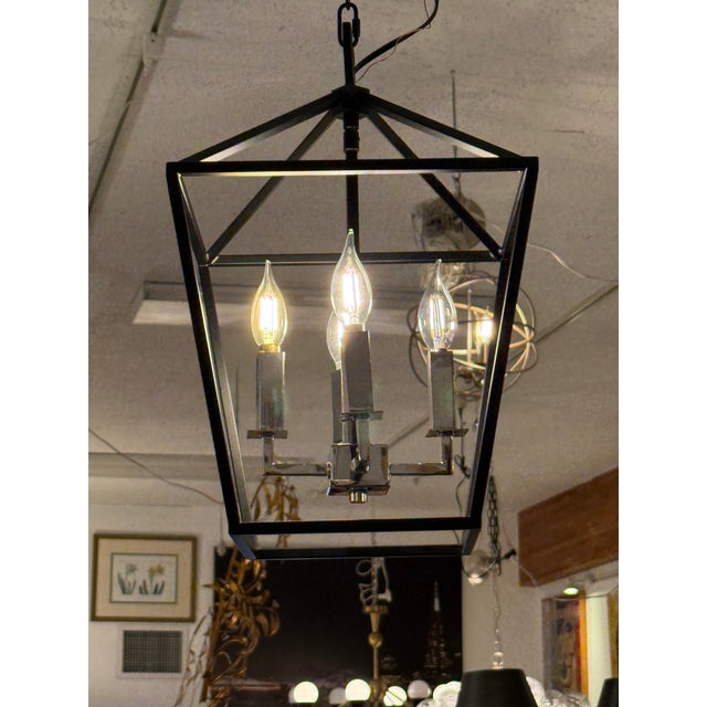 Design Plus Gallery presents the Abode Four-Light Small Chandelier from Maxim Lighting. The open steel lantern frame has...