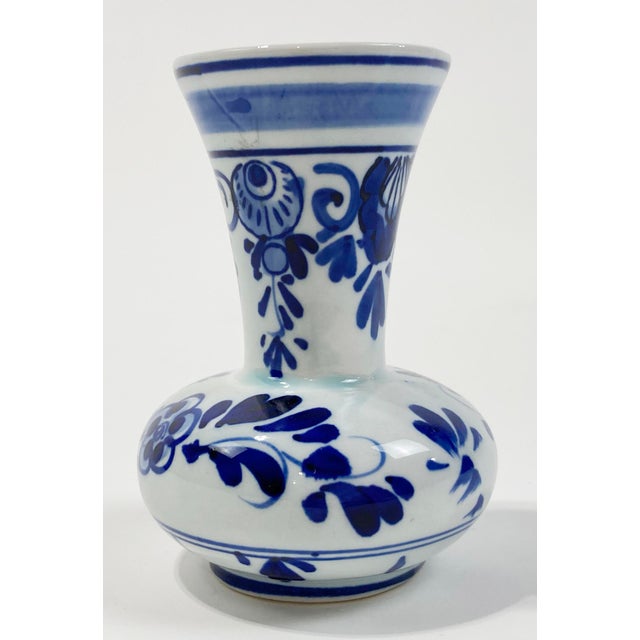 Vintage ceramic bud vase featuring classic blue and white Delft floral design. Marked on underside. Minor age wear. No...