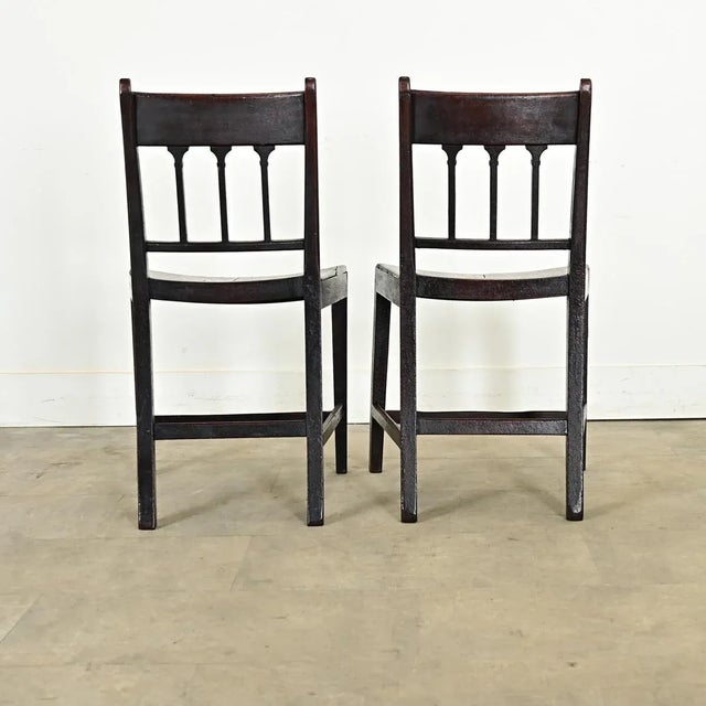 A handsome pair of carved oak George III style chairs from the 18th century. Look closely to appreciate the elegantly...