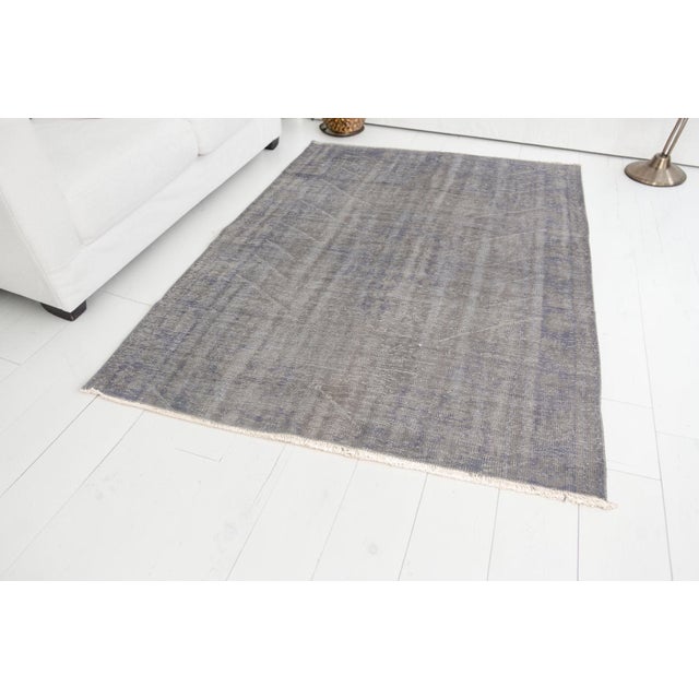 This is a vintage Turkish Oushak rug from the Mid 20th Century. The piece was hand-knotted.