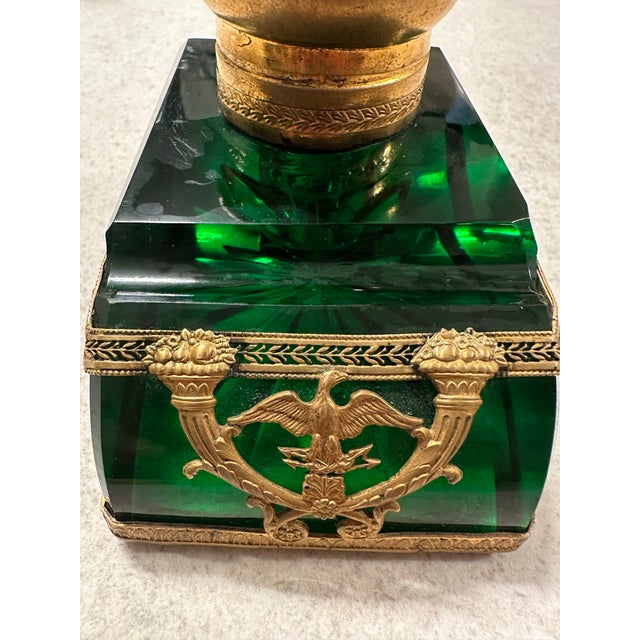 Striking emerald green glass inkwell in the French Empire style, accented with ornate gilt metal mounts and classical...