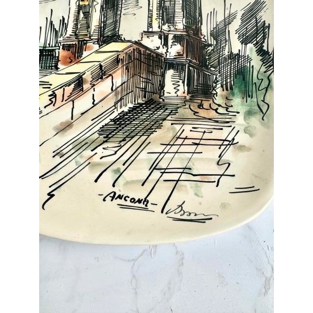 This exquisite hand-painted Italian wall plate features a detailed illustration of the Arch of Trajan in Ancona,...