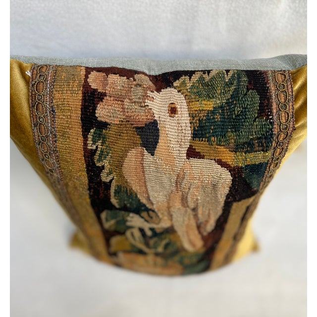 This decorative pillow is upholstered with an authentic 18th-century tapestry, showcasing a beautifully detailed bird...
