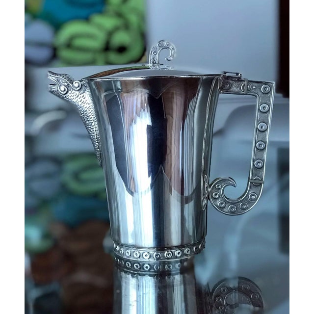 Modern sterling silver pitcher designed and crafted by Tane Orfebres in Mexico. The pitch is decorated with features of...