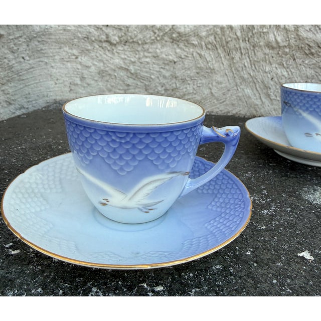 Eight piece porcelain tea cups with saucer manufactured by Bing & Grondalh, Copenhagen, Denmark. The tea cups feature a...