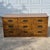 This is a vintage campaign style 9-drawer dresser made of a mix of wood and engineered wood clad in wood-tone laminate....