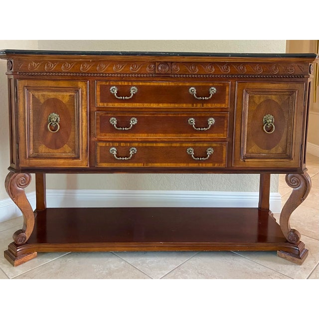 Neo Classical banded wood console table with rich Marble Top. Made by Universal Furniture Company. Intricate carving below...