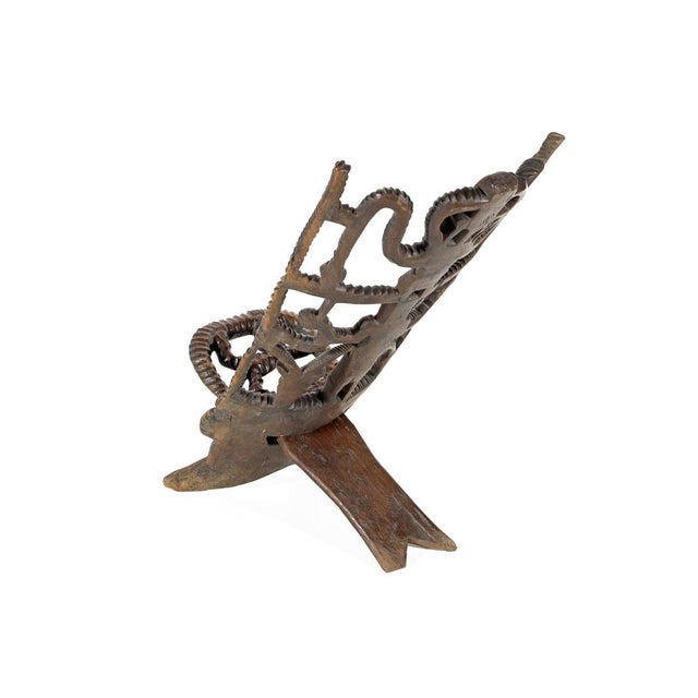 African ceremonial palaver chair, composed of two independent structural elements: a solid seat with V-shaped legs and a...