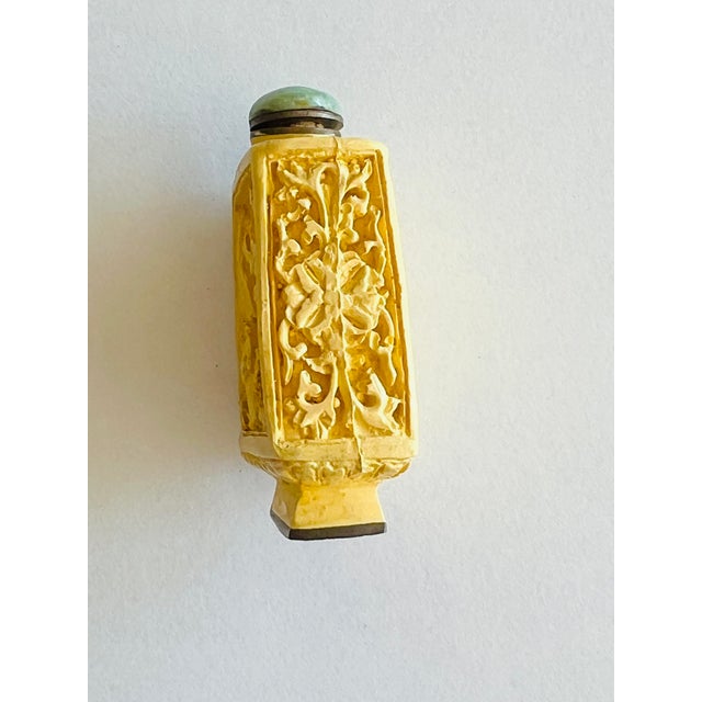 Light Yellow Carved Resin Snuff Bottle with Jade Stopper A beautifully detailed light yellow resin snuff bottle featuring...